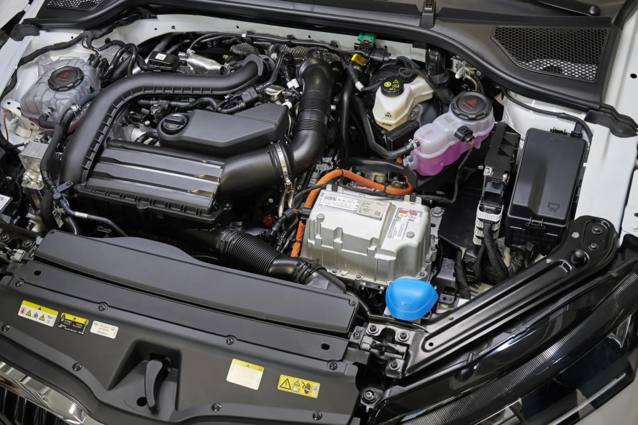 Bir otomobilin açık motor kaputu altındaki motor ve kablolar.